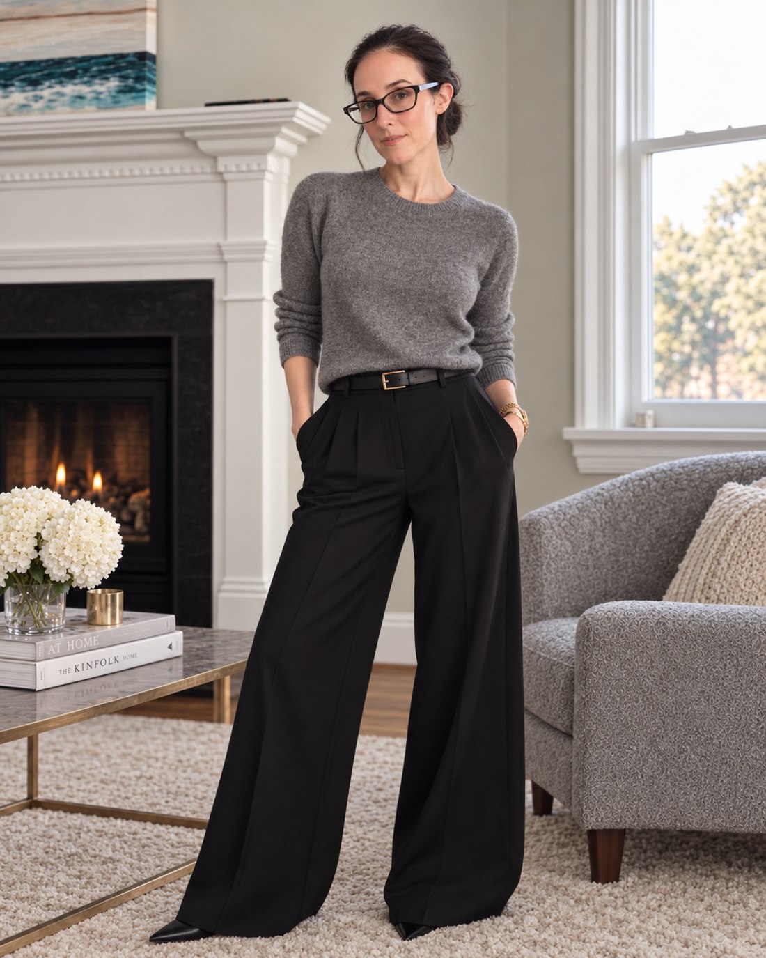 Kristin in gray knitwear and tailored trousers by the window